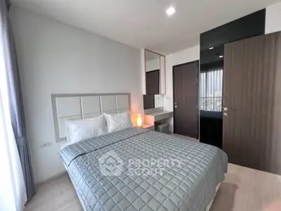 Modern bedroom with stylish decor and natural light, featuring a cozy bed and sleek furnishings.