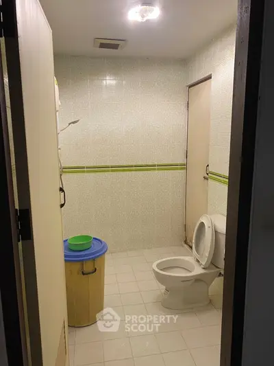 Simple bathroom with tiled walls and basic amenities