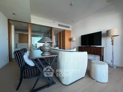 Spacious modern living room with stylish furniture and large TV, perfect for relaxation and entertainment.