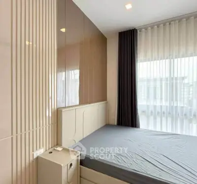 Modern bedroom with sleek design and large window offering natural light