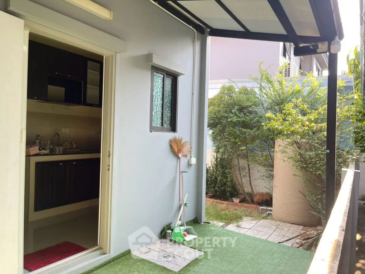 Charming backyard with covered patio and lush greenery, perfect for relaxation and outdoor activities.