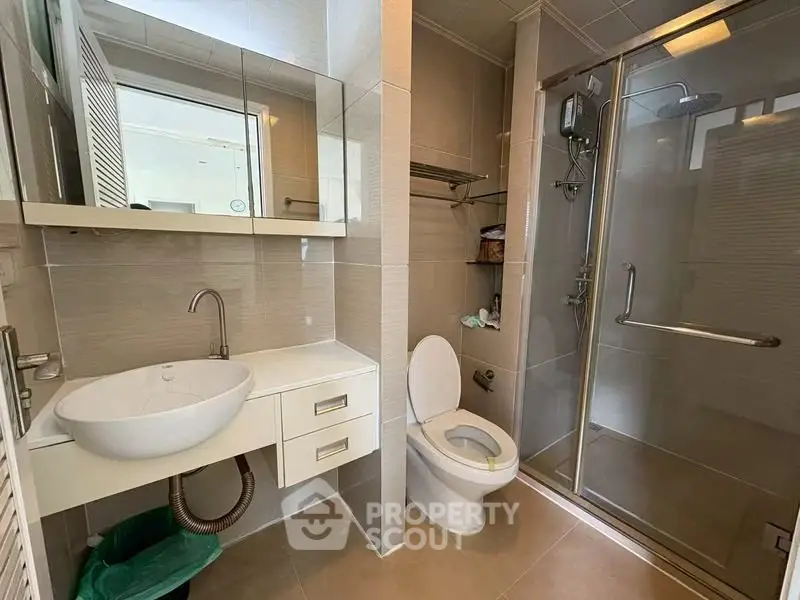 Modern bathroom with glass shower and sleek fixtures in a contemporary home.