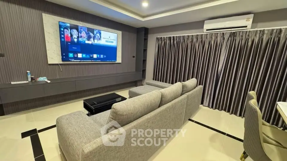 Modern living room with large TV and stylish gray sofa