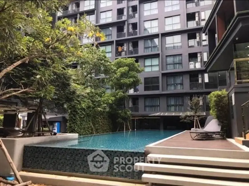 Modern apartment complex with luxurious pool and lush greenery