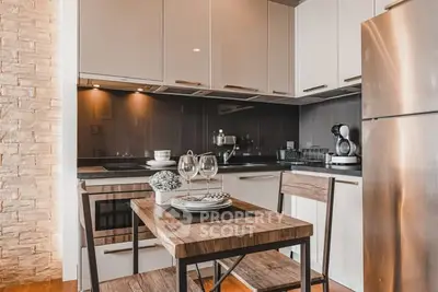 Modern kitchen with sleek cabinets, stainless steel appliances, and cozy dining area.