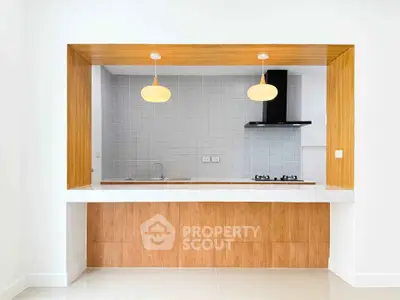 Modern open kitchen with wooden accents and gas stove, perfect for culinary enthusiasts.