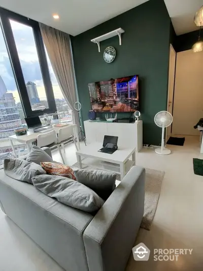 Modern living room with large windows and city view, featuring stylish decor and comfortable seating.