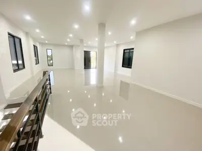 Spacious open-plan living area with modern lighting and large windows