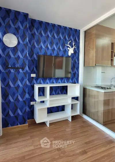 Modern living room with stylish blue geometric wallpaper and sleek white TV stand