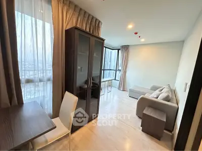 Modern living room with large windows and stylish furniture in a high-rise apartment.