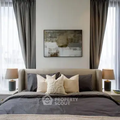 Luxurious bedroom with elegant decor and natural light, featuring stylish bedding and modern art.
