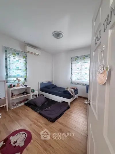 Cozy bedroom with wooden flooring and minimalist decor