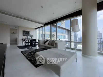 Luxurious modern living room with panoramic city views and elegant furnishings in a high-rise apartment.