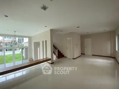 Spacious modern living room with large windows and garden view, perfect for family gatherings.