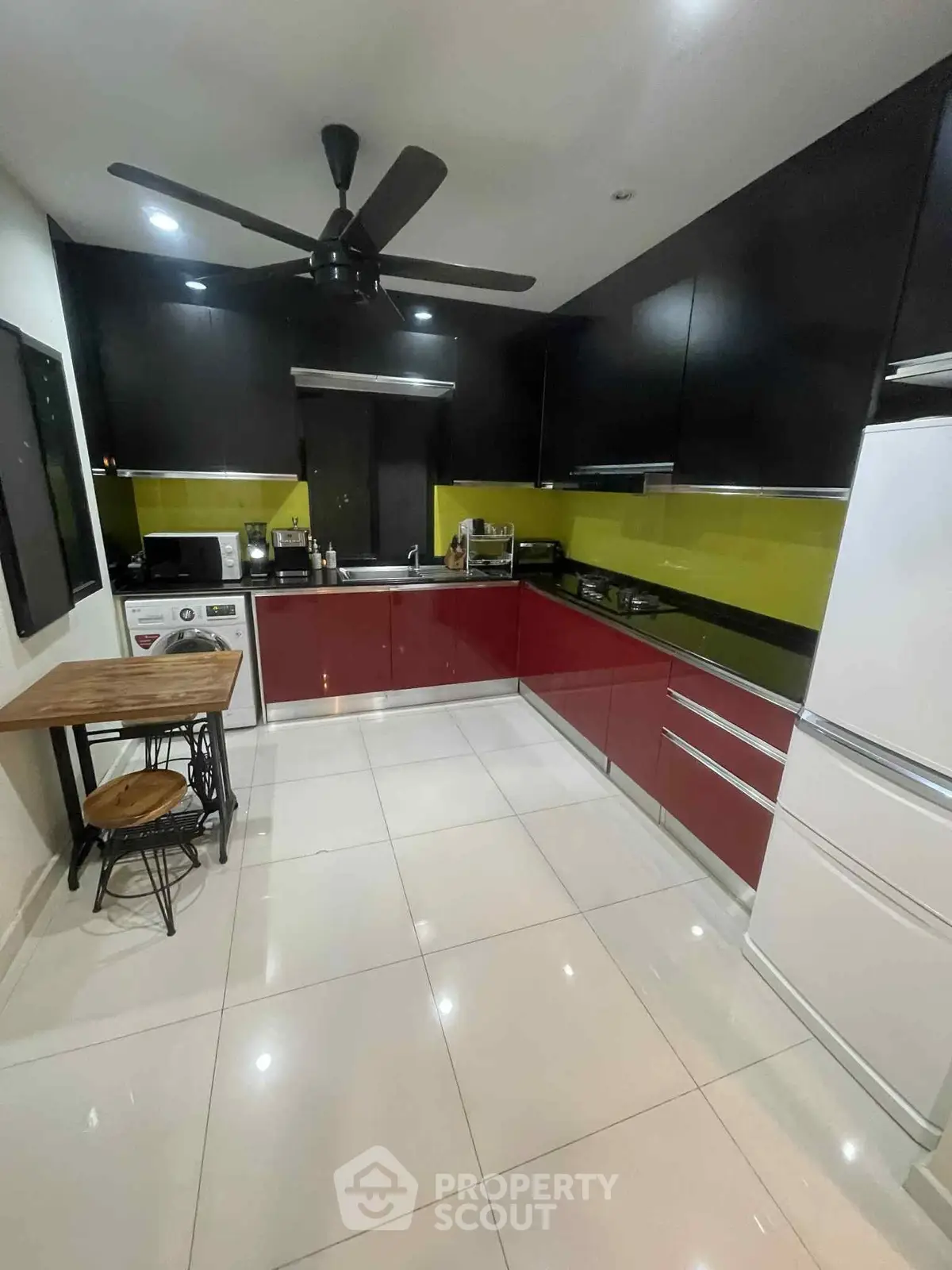 Modern kitchen with sleek cabinetry and vibrant backsplash, featuring appliances and a cozy dining nook.