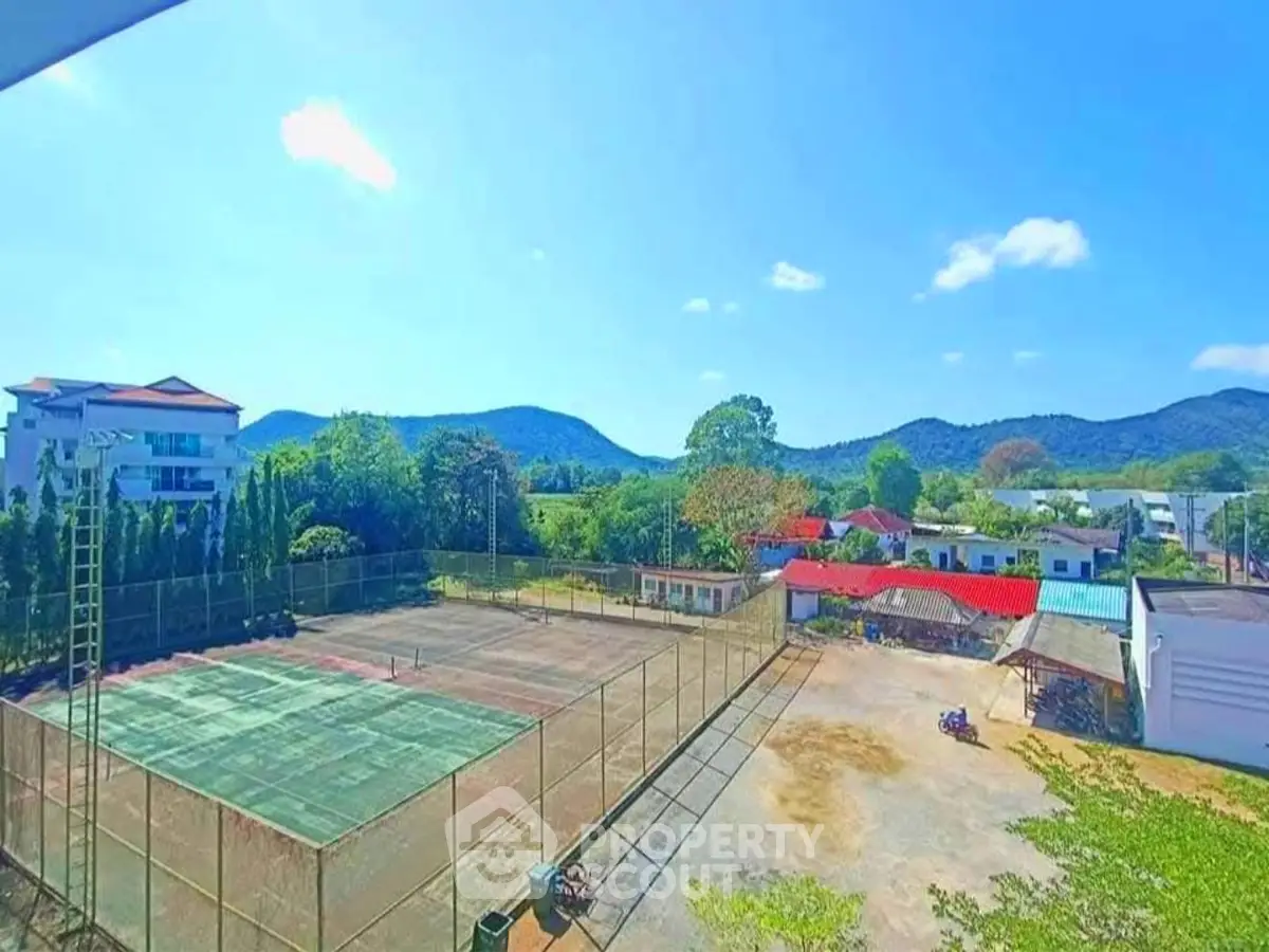 Scenic view of tennis court with mountain backdrop in residential area