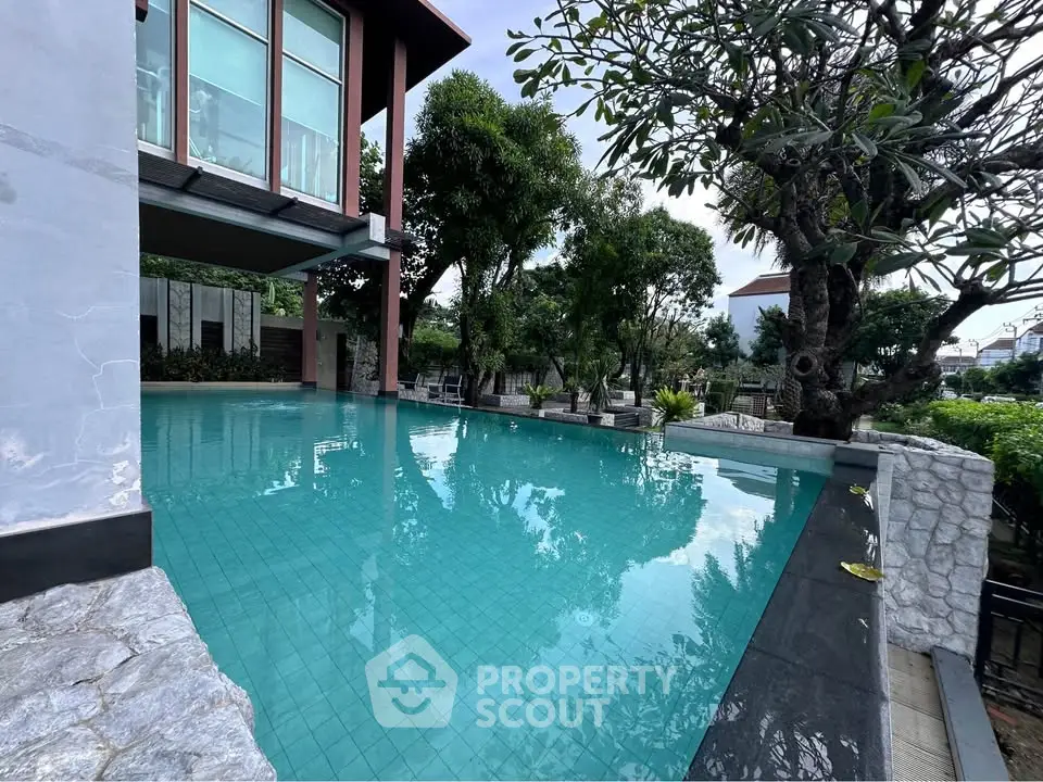 Luxurious infinity pool surrounded by lush greenery and modern architecture, perfect for relaxation and leisure.