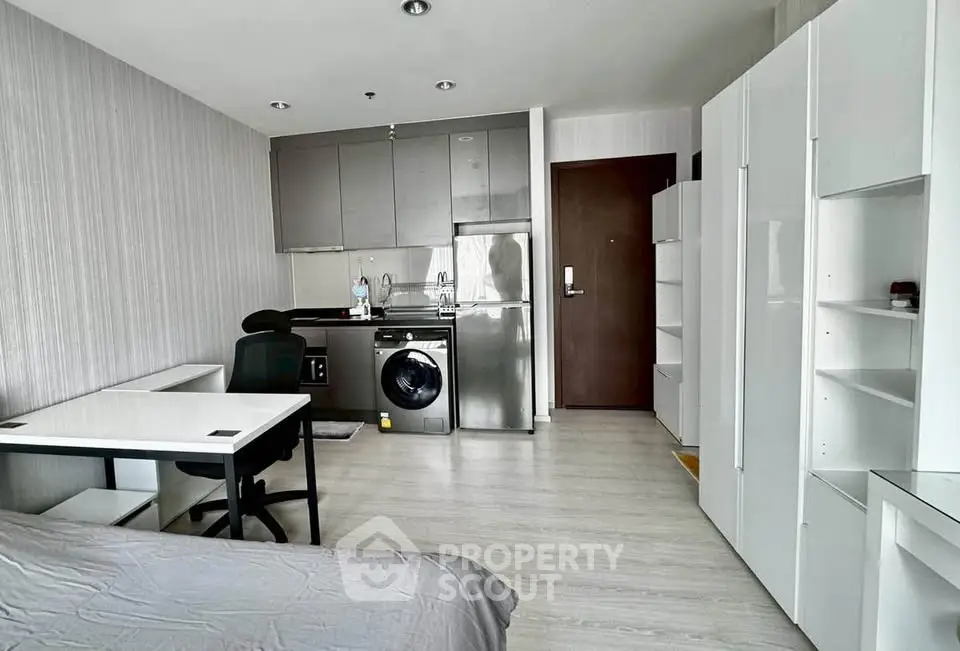 Modern studio apartment with sleek kitchen and integrated washing machine