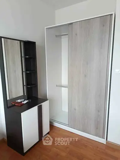 Modern bedroom with sleek wardrobe and stylish dresser, perfect for contemporary living.
