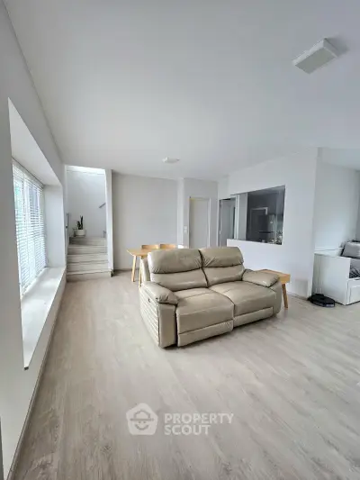 Spacious modern living room with sleek flooring and natural light