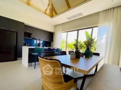 Spacious modern kitchen with open layout and elegant dining area, featuring large windows and stylish decor.