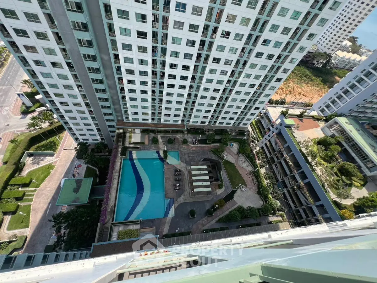 High-rise building with pool view from above, showcasing modern urban living.