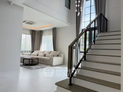 Elegant modern living room with high ceilings and stylish staircase