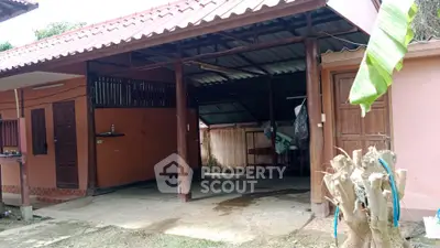 Charming rustic home with open garage and traditional design, perfect for countryside living.