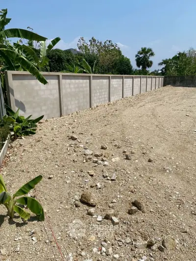 Spacious vacant land with boundary wall, ideal for development opportunities.