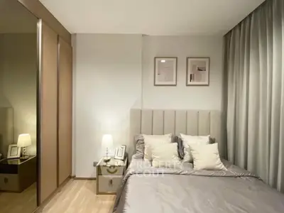 Elegant bedroom with modern decor, plush bedding, and mirrored wardrobe in a cozy apartment.