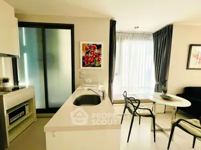Modern open-layout kitchen and living area with stylish decor and natural light.