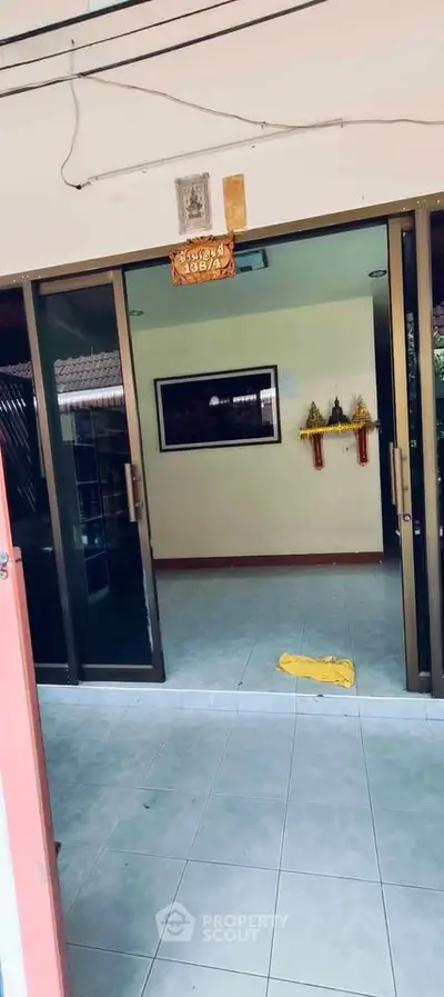 Spacious entrance with sliding glass doors and tiled flooring