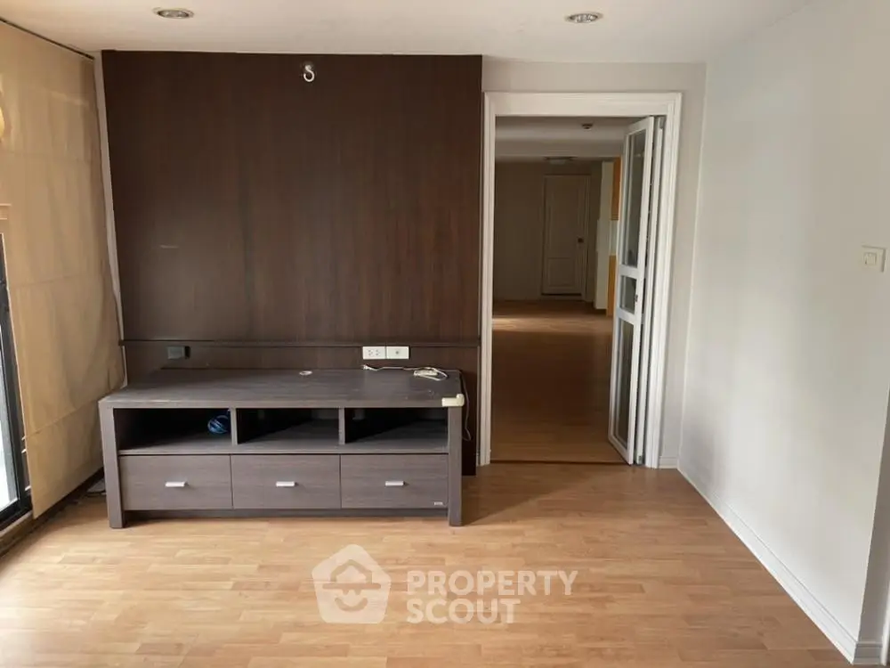 Spacious living room with wooden flooring and modern entertainment unit