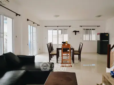 Spacious living and dining area with modern furniture and natural light.