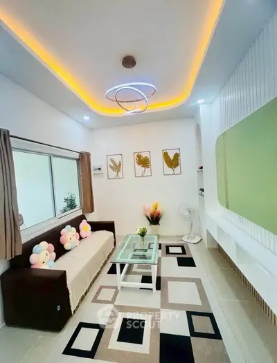 Modern living room with stylish ceiling lights, geometric rug, and cozy sofa in a contemporary apartment.