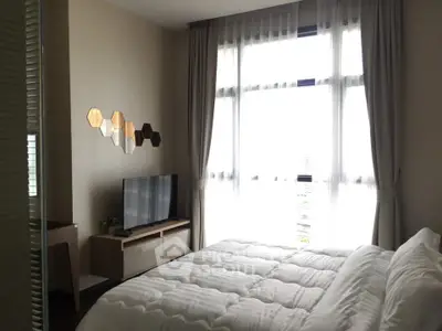 Modern bedroom with large window and stylish decor in a high-rise apartment.
