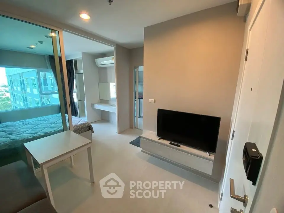 Modern apartment interior with bedroom and living area, featuring sleek design and natural light.