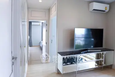 Modern living room with sleek TV setup and air conditioning in a stylish apartment.