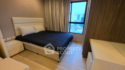 Modern bedroom with city view, featuring sleek furniture and cozy ambiance.