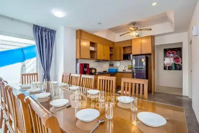 Spacious dining area with wooden furniture and modern kitchen in open layout