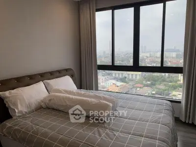 Modern bedroom with large window offering stunning city view