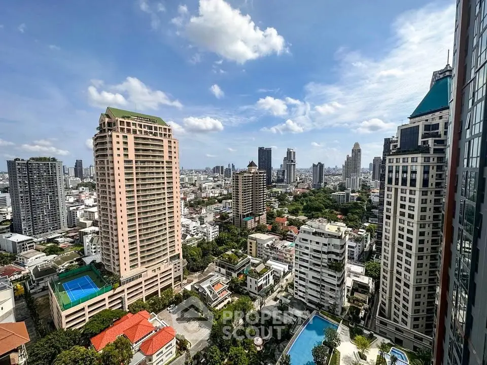 Stunning cityscape view from high-rise building with pool and lush greenery.