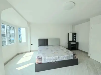 Spacious bedroom with modern decor and ample natural light