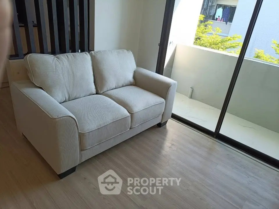 Modern living room with cozy sofa and balcony view, perfect for relaxation.