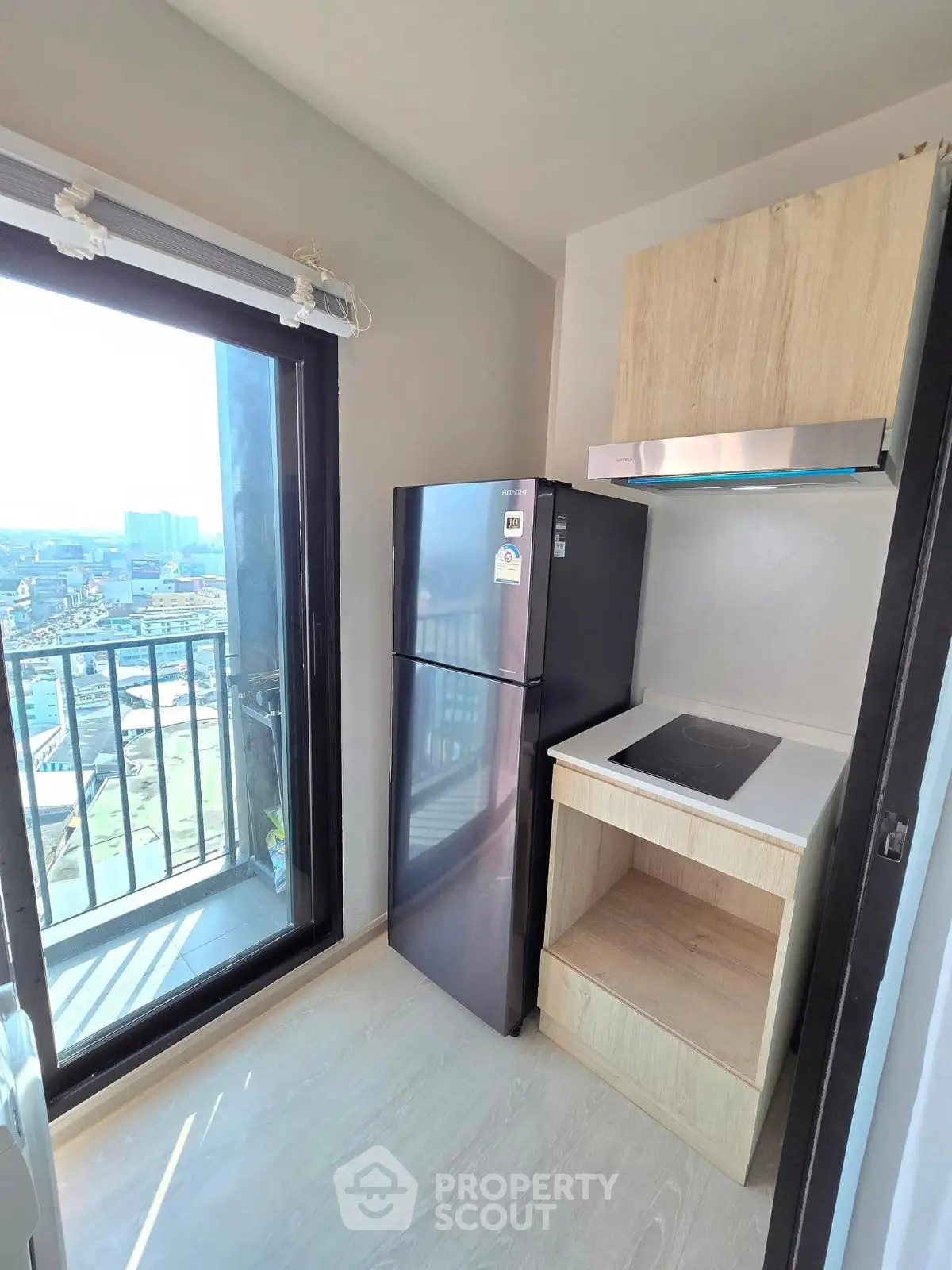 Modern kitchen with sleek appliances and city view from balcony