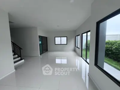 Spacious modern living room with large windows and glossy tiled floor