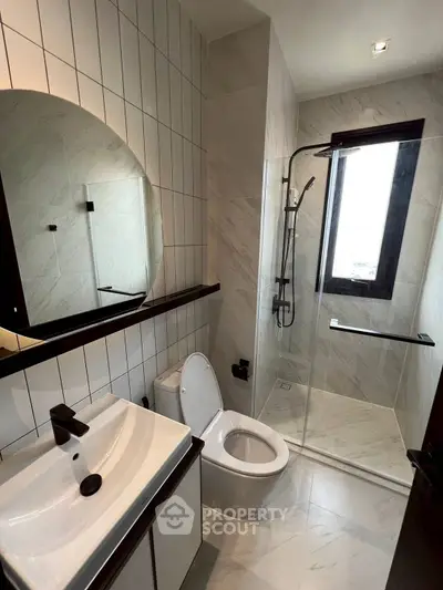 Modern bathroom with sleek design and glass shower enclosure.