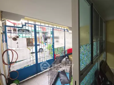 Cozy balcony with decorative tiles and secure metal gate in urban setting.