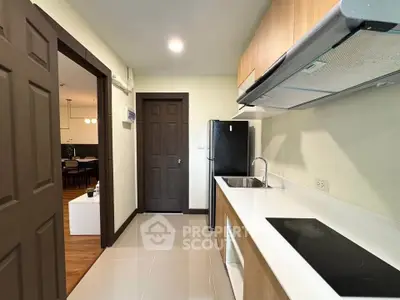 Modern kitchen with sleek appliances and open layout leading to dining area