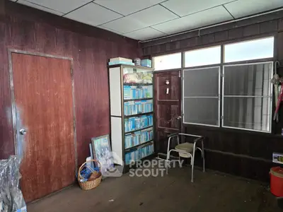 Cozy wooden interior with bookshelf and window, perfect for a study or reading nook.